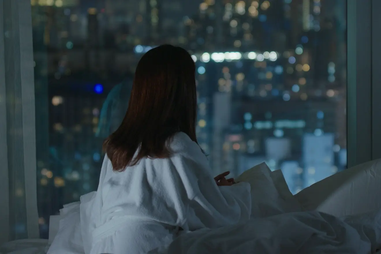夜中に目が覚めて起きている女性の写真