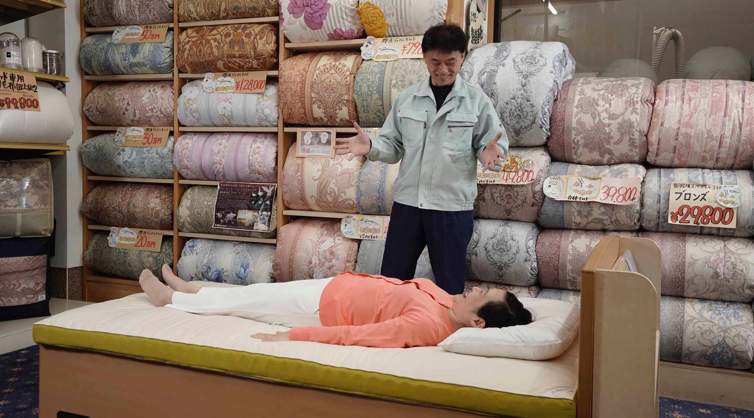 櫻道ふとん店で腰いい寝リッチ温泉羽毛マットレスを体験している女性